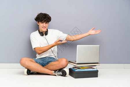 年轻人用笔记本电脑坐在一楼的地板上背景图片