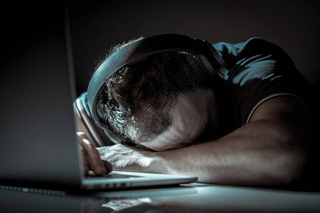 白种男人睡在笔记本电脑上勤劳的办公室工人休息时间过短疲惫背景图片