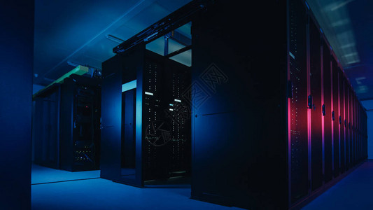 具有多行完全可操作的服务器机架的数据中心的镜头现代电信云计算人工智能数据库超级计算机技术概念用霓虹蓝粉红色的灯光图片