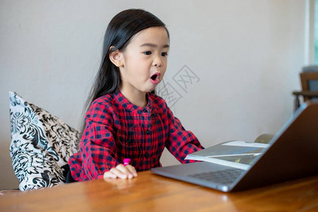 亚洲女孩或女儿在学校期间使用笔记本和技术进行在线学习图片