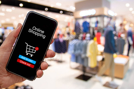 使用智能手机购买和通过模糊购物中心背景应用进行数字支付的人图片