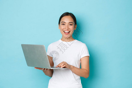 使用笔记本电脑微笑着快乐美丽的亚洲妇女图片