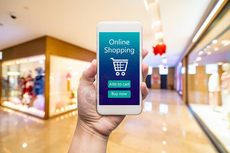 智能手机在线购物在女人手中背景中的购物中心通过电子商务网站购买图片