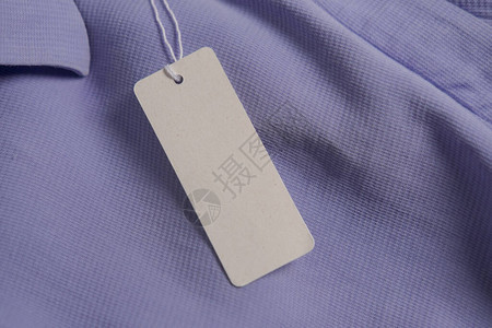 紫衣棚织物上的服装纸标签时装品牌名称模拟关闭顶视图图片