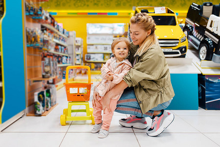 快乐的妈带着小女儿在童商店妈和孩子一起在超市挑选玩图片