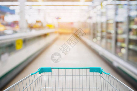 在超市AisleMilkYegurtFrozen食品冷冻器和有客户偏注背景的壳牌中图片