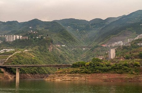 长江西陵峡谷峡谷上的2座公路桥流入长江后面的高山与洒满建筑物棕色的天图片