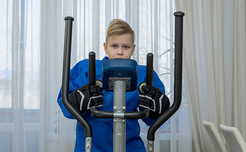 身穿蓝色T恤的年轻曲棍球运动员正在家中参加一个静脉训练师图片