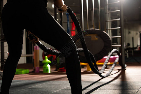 健身女人运动的背面图用战绳热身伸展概念女人可以做运动员运动图片