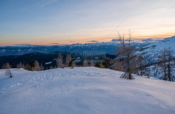 壮观的冬天山全景山在日落太阳在白雪皑的山脊和山峰后落山斯洛文图片