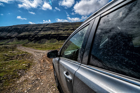4WDSUV汽车在冰岛自然山区风景的碎石路上运行图片