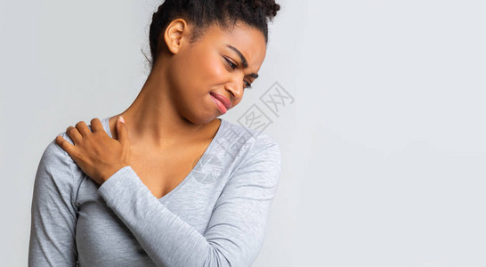 患有肩部疼痛保健和医疗概念的年轻黑人妇女图片