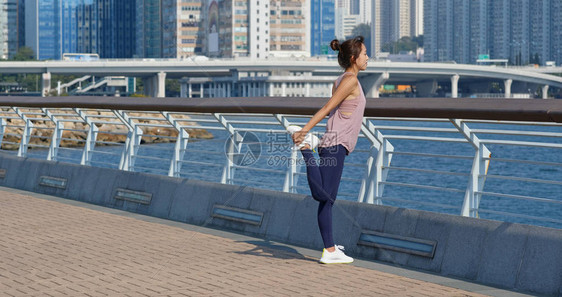 女人在户外跑步前伸腿图片