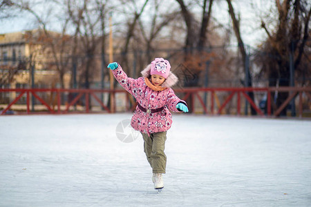 女孩不知觉地站立在冰场滑雪板图片