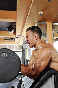 亚洲无上衬衫肌肉运动员在健身房用巴铃举图片