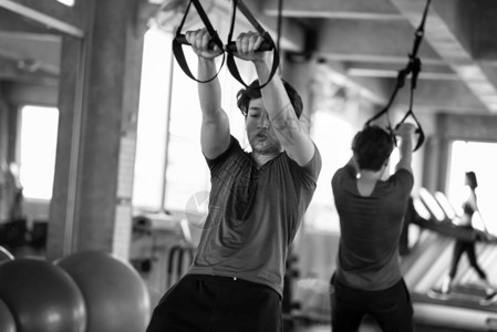 美国年轻人用腹带在健身房用镜子反射健美运动和健康的生活方式概图片
