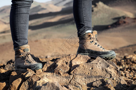 游客穿着徒步登山靴站在石头上图片