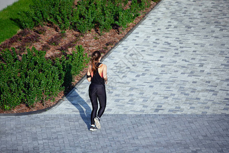 穿运动服的妇女沿着城市的灰色图片