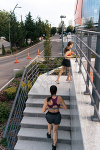 年轻女子早上在楼梯上奔跑健康意识的概念健康积极的生活方式活跃的女孩们在城市的道图片