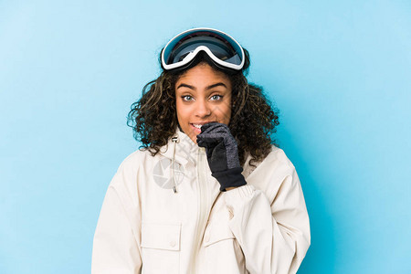 年轻的非裔美国滑雪女子孤立的咬指甲紧图片