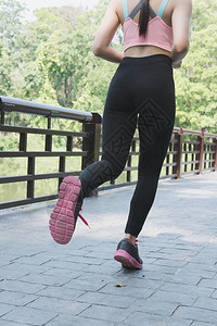 女运动员在春季或夏季的桥上户外跑步图片