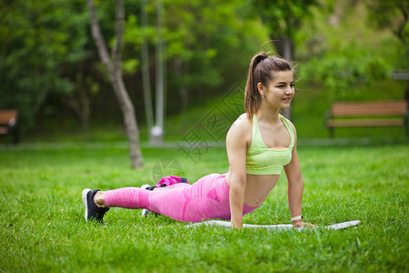 在公园户外的一个垫子上做瑜伽伸图片