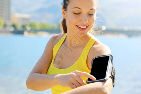跑步运动员听的音乐来自智能电话mp3玩家智能手机臂带女健身慢跑图片