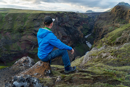 站在冰岛Laugavegur小径路上的高山和峡谷背景的白种人年轻人提倡健图片
