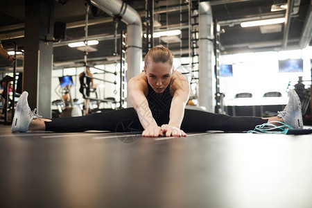 金发年轻金发女子在健身复制空间享受健身锻炼时图片
