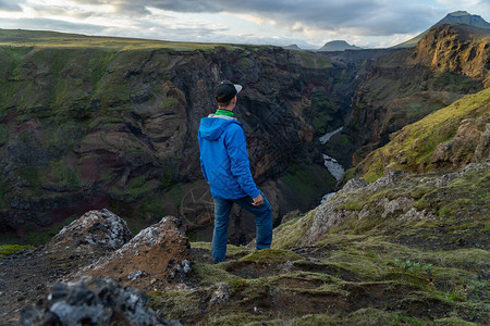 站在冰岛Laugavegur小径路上的高山和峡谷背景的白种人年轻人提倡健图片