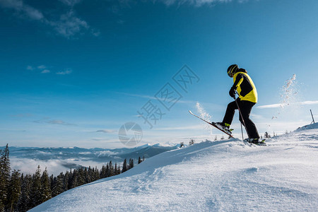 山上滑雪者持滑雪棍和踩踏天图片