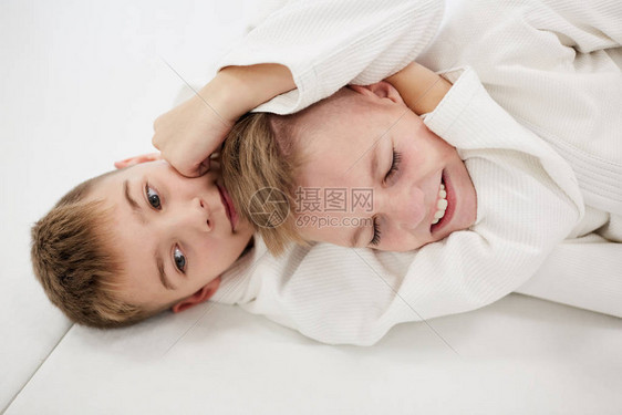 两个男孩躺在地上在空手道训练期间图片