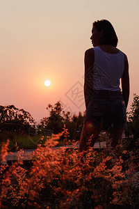 站在夕阳下的女人的背影图片