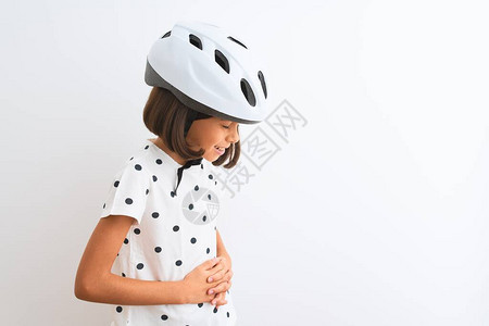 戴着安全自行车头盔的漂亮女孩站在孤立的白色背景上图片