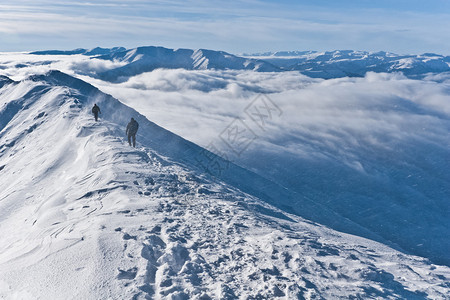 山顶上的暴风雪有两个登山者图片