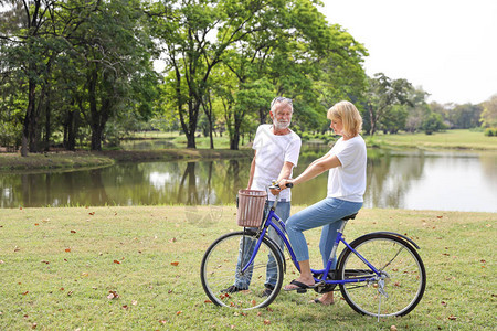 周末在公园骑自行车的高级男女老人和妇女图片