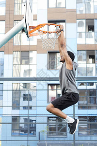 非洲篮球运动员在户外法庭复制空间训练时跳到环球的侧对角图片