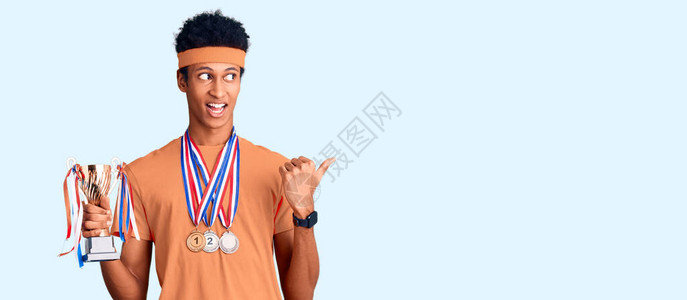 持有冠军奖杯的美国青年男子佩戴勋章图片