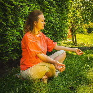 中年妇女坐在绿色花园背景的沉思图片