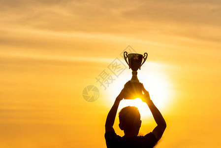 奖剪影最佳奖胜利奖杯为职业冠军挑战队在头顶举起金色运动奖杯双背景