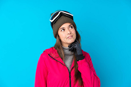 带着滑雪眼镜的青少年滑雪女孩与孤立的蓝背景图片