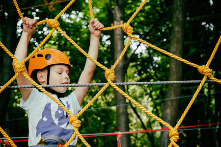 男孩爬上绳索公园图片