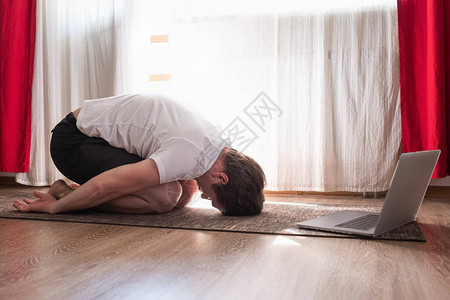 白人成年男子在网上课程上做瑜伽时图片