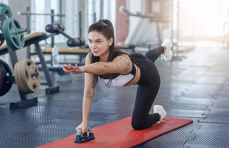 在健康俱乐部的瑜伽垫上做平衡或伸展锻炼的图片