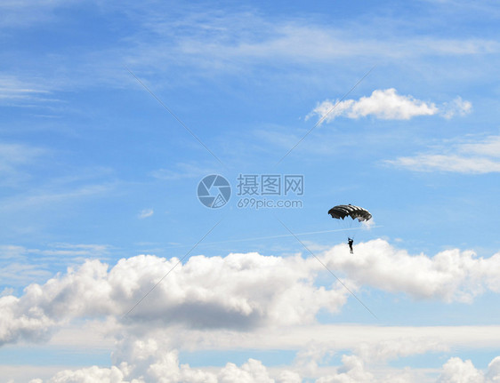 反对蓝色多云天空的伞兵图片