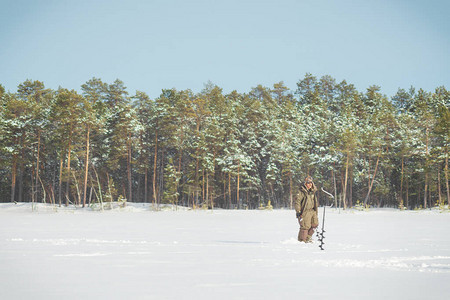 冬天季捕冬钓鱼两个渔民在森林背景下图片