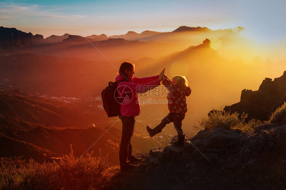 母亲和小女儿在日落山上享受旅行图片