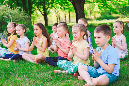 大批儿童坐在草地上在公园图片