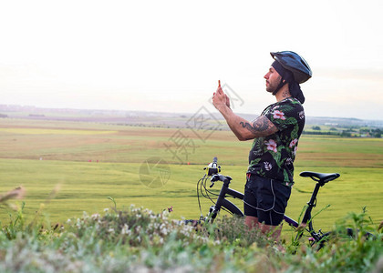 骑自行车的骑自行车者下车在日落时用图片