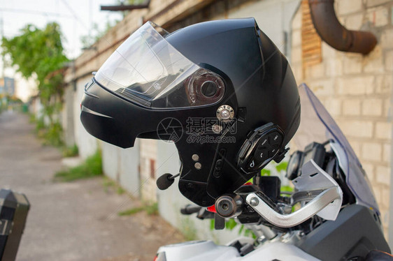 摩托车手的防撞头盔挂在摩托车的把手上头盔挂在摩托车的方向盘上骑自行车的人和图片